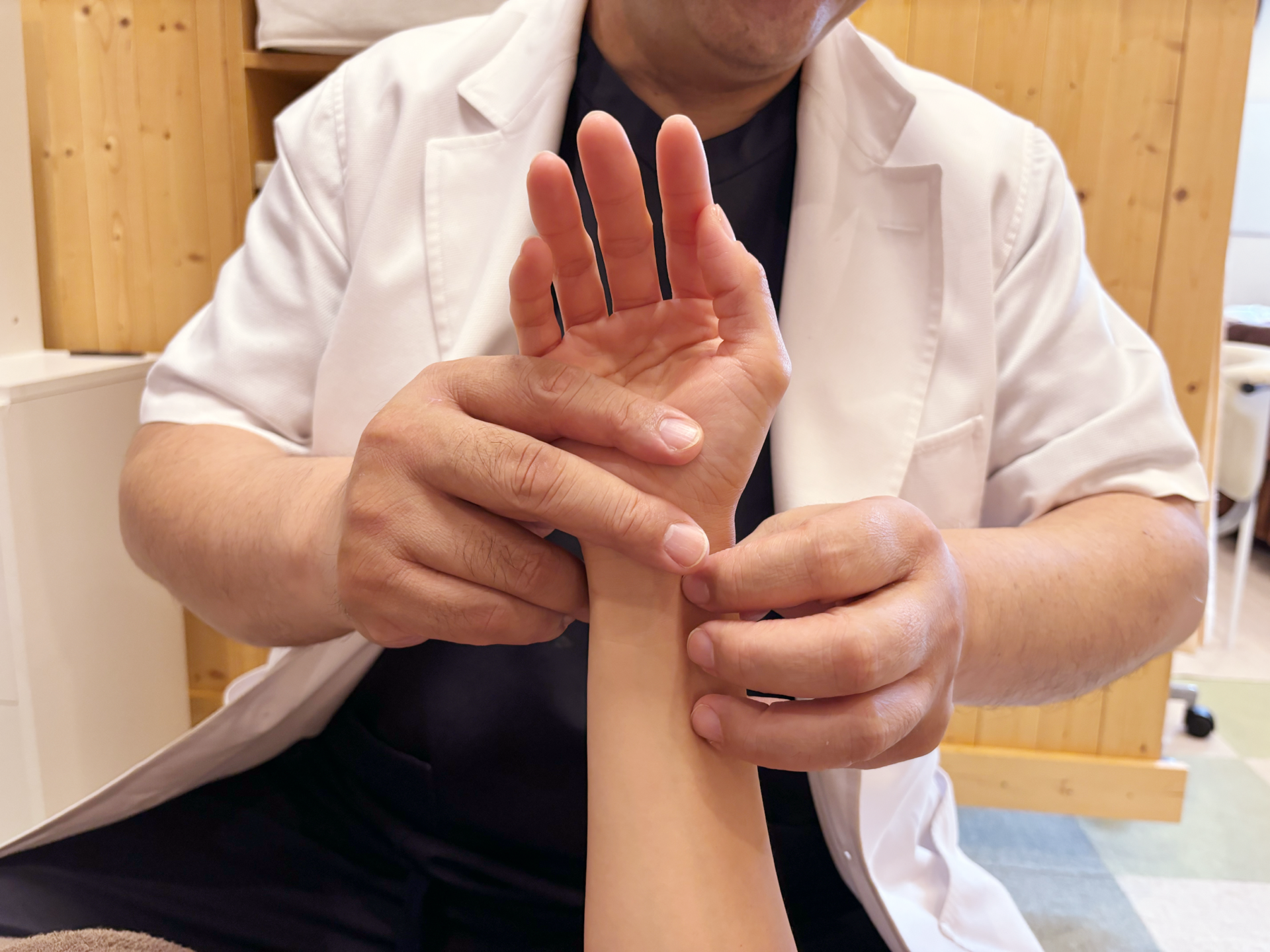 経絡治療の施術前に手首の脈を確認している様子