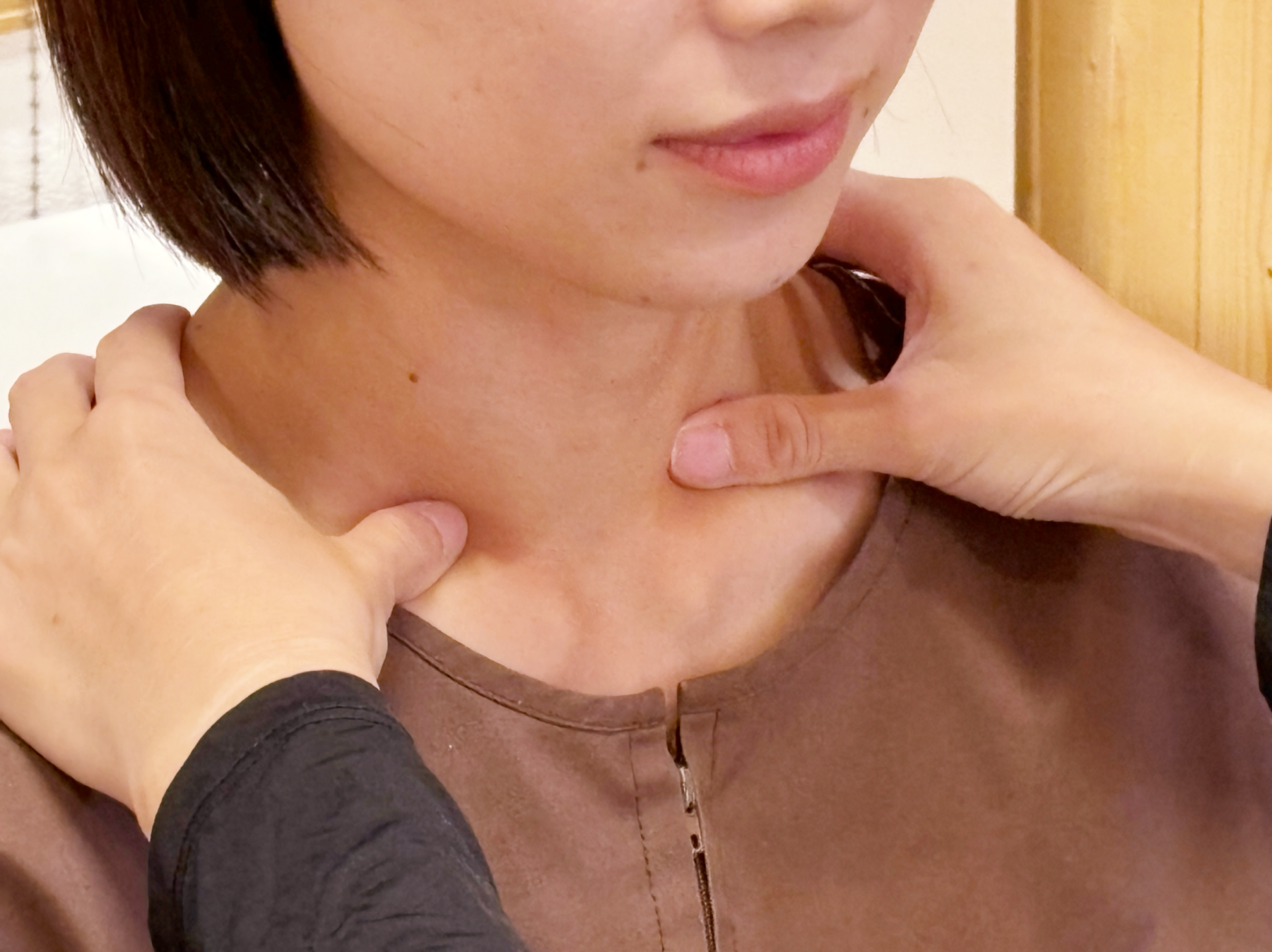 肩こりやめまいの施術前に首肩周囲の状態を確認している様子